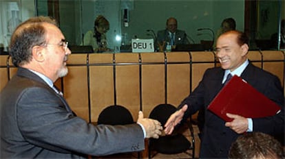 El ministro de Economía español, Pedro Solbes (izquierda), saluda al primer ministro italiano, Silvio Berlusconi, al inicio de la reunión del Ecofin.