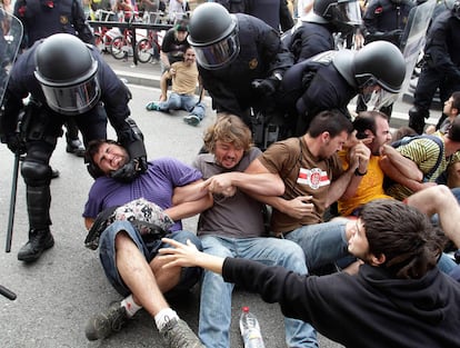 Un policía trata de levantar a un manifestante durante la protesta contra el campamento en Plaza Cataluña.