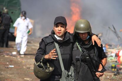 Dos policías se alejan del campamento establecido por los partidarios del presidente derrocado islamista Mohamed Morsi en Nasr City distrito, El Cairo, Egipto.