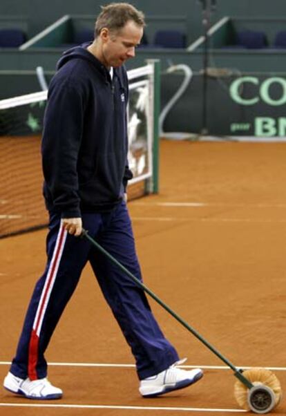 Patrick McEnroe pinta las líneas de la pista de La Cartuja.