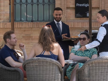 Dos trabajadores en la terraza de un restaurante de Sevilla este jueves, vestidos con mangas largas, pese a las altas temperaturas.