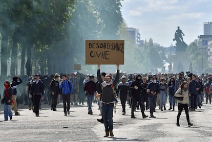 A young man holds a placard reading "Civil Disobedience" as demonstrators take part in a protest against the French government's proposed labour reforms on April 28, 2016 in Nantes, western France. 
Protests turned violent in Paris and other French cities today as tens of thousands of workers and students made a new push for the withdrawal of a hotly contested labour bill. / AFP PHOTO / LOIC VENANCE