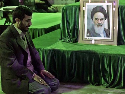 El presidente iraní, Mahmud Ahmadineyad, reza ante un retrato del ayatolá Jomeini, ayer en Teherán.