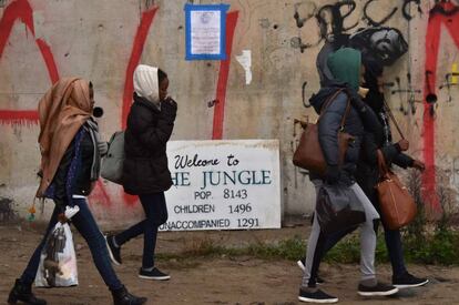 Migrantes caminan a la zona donde serán registrados antes de abandonar el campamento de Calais (Francia).