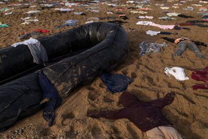 Detalle de una lancha neumática y decenas de prendas colocadas en la arena de la playa barcelonesa de San Sebastián, este lunes.