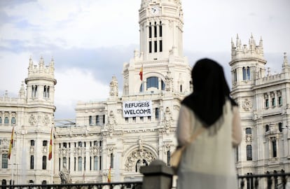 Una mujer observa la pancarta de bienvenida a los refugiados que cuelga de la fachada del Ayuntamiento. 