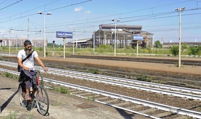 Un inmigrante pasea en bici por la estación de Sesto San Giovanni.