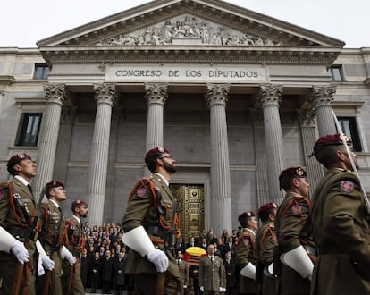 El féretro de Adolfo Suárez, portado por un piquete de honor, abandona el Congreso por la escalinata de la Puerta de los Leones, en presencia de compañías de los tres ejércitos y de la Guardia Civil.