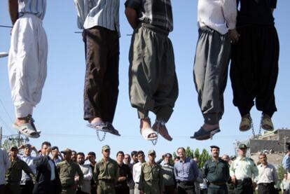 Un grupo de personas observa los cuerpos de cinco ahorcados en Mashad (Irán) el 1 de agosto de 2007. Algunos de los asistentes toman fotos de los ejecutados.