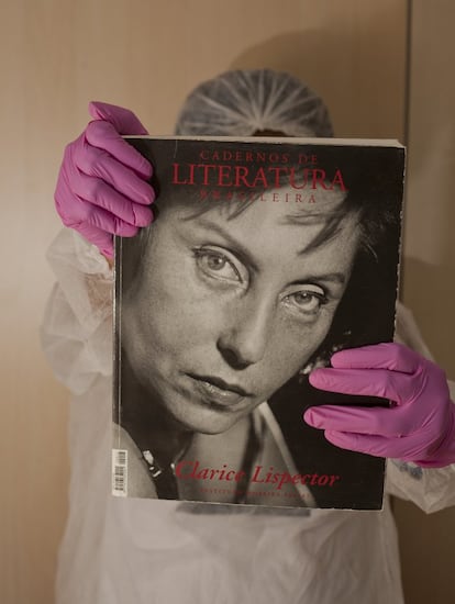 A bibliotecária Jane Leite, do IMS, segura uma publicação sobre a obra de Lispector.