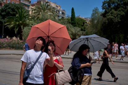 Turistas se protegen del sol en el centro de Barcelona, el lunes.