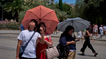 Turistas se protegen del sol en el centro de Barcelona, el lunes.