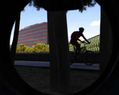 Un ciclista a su paso por el puente de Andorra, con el hotel NH Madrid Ribera del Manzanares al fondo.