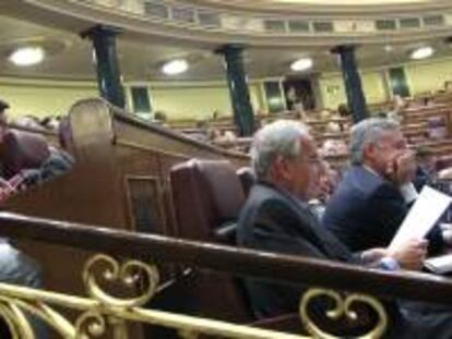 El portavoz parlamentario de IU, Cayo Lara (i), y el diputado del PSOE Alfonso Guerra (d), sentados siguen desde sus escaños el pleno del Congreso de los Diputados. EFE/Archivo
