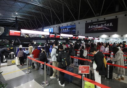 El viajar como religin: pasajeros haciendo cola en el embarque de un vuelo en el aeropuerto de Pekn.