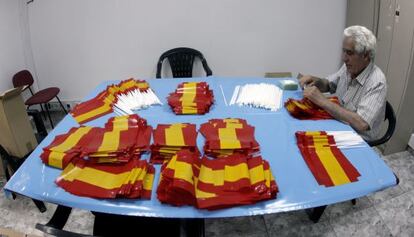Un trabajador de la empresa valenciana montando los pequeños estandartes.