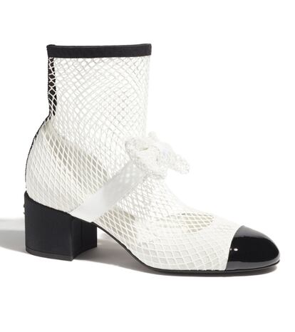 La malla blanca convierte estas ‘Mary Janes’ bicolores firmadas por Chanel en unos particulares botines ‘al aire’, rematados con un lazo, también en este tejido. 1.650 €