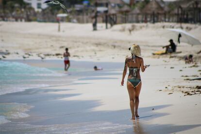 Una mujer camina en Playa Ballenas, en Cancún, a inicios de agosto.