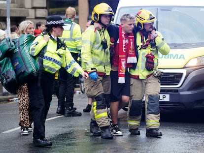 Dos trabajadores de emergencias evacúan a uno de los afectados por el atropello múltiple esta tarde en la ciudad inglesa.