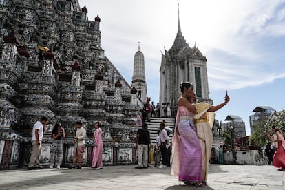 Visitantes (algunos vestidos con trajes típicos) en el Wat Arun, en Bangkok.