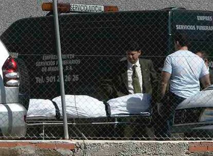 Empleados de la funeraria trasladan el cadáver de María Eugenia Bravo.