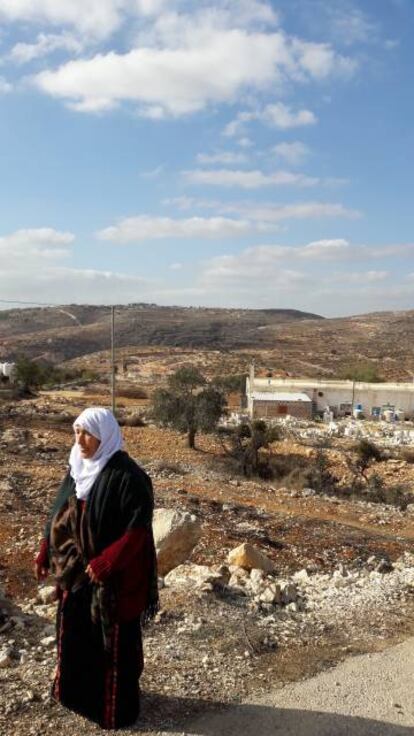 Una campesina palestina del pueblo de Silwad que perdió su tierras en Amona, situado en la colina del fondo.