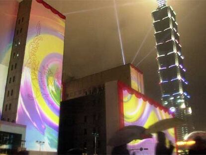 Luces de colores en la fachada del Ayuntamiento de Taipei, junto al que emerge, en forma de caña de bambú o de pagoda, el rascacielos Taipei 101.