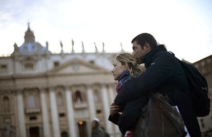 Una pareja mira una de las pantallas gigantes instaladas en la plaza de San Pedro durante la primera homilía del papa Francisco.