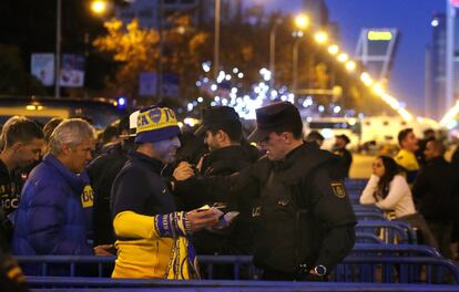 Un seguidor del Boca Juniors es registrado por un agente de la Policía Nacional en uno de los accesos al estadio Santiago Bernabéu. 