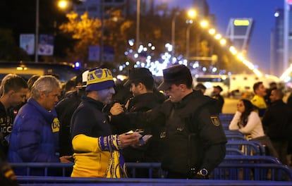Un seguidor del Boca Juniors es registrado por un agente de la Policía Nacional en uno de los accesos al estadio Santiago Bernabéu.