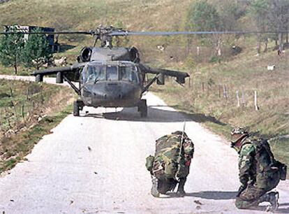 Dos <i>cascos azules</i> de EE UU se protegen durante el aterrizaje de un helicóptero de la OTAN en Bosnia.
