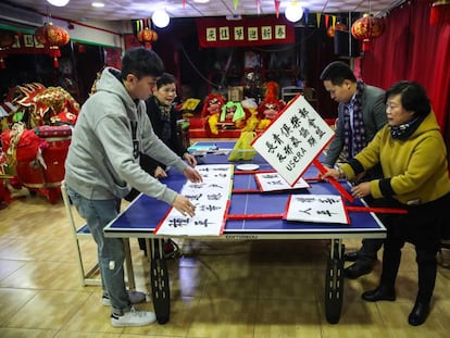 Socios del Centro de Mayores Chinos de Usera preparan los carteles para la manifestación de este viernes en Madrid contra los bloqueos masivos de cuentas de banco.