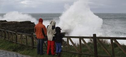 Una familia observa el fuerte oleaje en Ribadeo (Lugo).