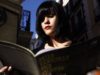 Una joven lee el catálogo de actividades de 'La noche de los libros'.