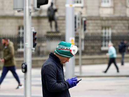 Un hombre consulta su teléfono, este martes en las calles de Dublín.