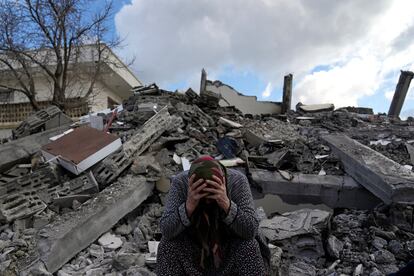 Una mujer, junto a los escombros de un edificio destruido por el terremoto en Nurdagi, en el sur de Turquía, el martes.