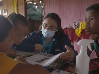 Adriana López da clase a Michelle en su casa, en presencia de sus hermanos, en Cascales (Sucumbíos, Ecuador).