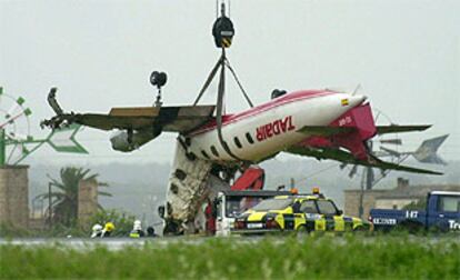 Una grúa comienza a retirar los restos de la avioneta que se estrelló esta madrugada en el aeropuerto de Son San Joan.