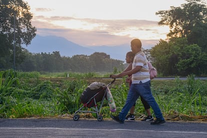 Una familia de migrantes camina en Ciudad Hidalgo, Chiapas, acompañada de la caravana que partió hacia la frontera de México con Estados Unidos.