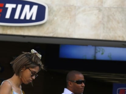 Una usuaria utiliza su móvil frente a una tienda de TIM en Río de Janeiro.