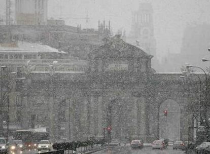 Vista de la Puerta de Alcalá durante la nevada caída ayer al mediodía en el centro de Madrid.