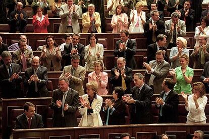 Zapatero, sentado en su escaño, aplaudido por los parlamentarios del PSOE, tras una de sus intervenciones ante el Congreso.
