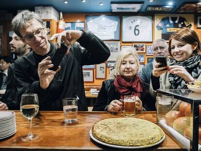 Unos comensales fotografían la famosa tortilla del bar Nestor, en San Sebastián.