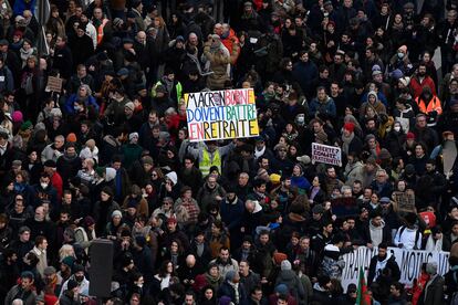 El activista francés Jean-Baptiste Redde, también conocido como Voltuan (centro), sostiene un cartel que dice "Macron, Borne debe retirarse" durante una manifestación en París, este martes.