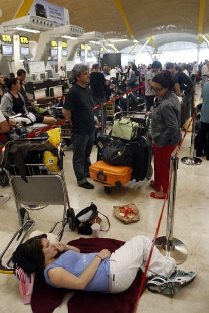 Viajeros atrapados en el aeropuerto madrileño de Barajas, ayer.
