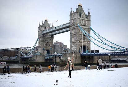 Una mujer posa frente con el Puente de la Torre de fondo. 