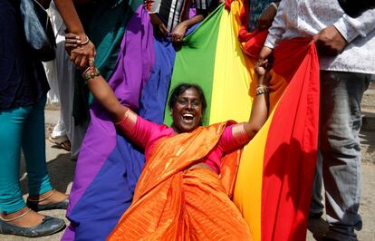 Una activista sobre una bandera LGTB celebra la sentencia del Tribunal Supremo en Bengaluru (India).