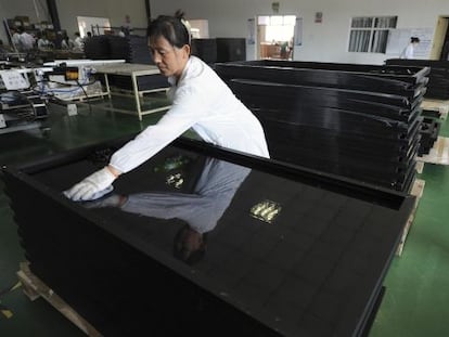 Una empleada limpia paneles solares reci&eacute;n fabricados en la ciudad china de Hefei.