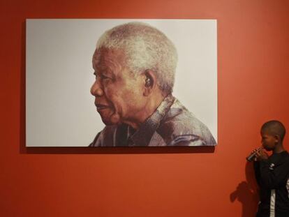 Menino diante foto de Mandela, exposta na sua fundação.