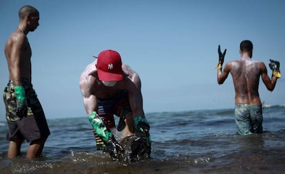 Voluntários retiram óleo na praia de Itapuama, na cidade de Cabo de Santo Agostinho, Pernambuco.